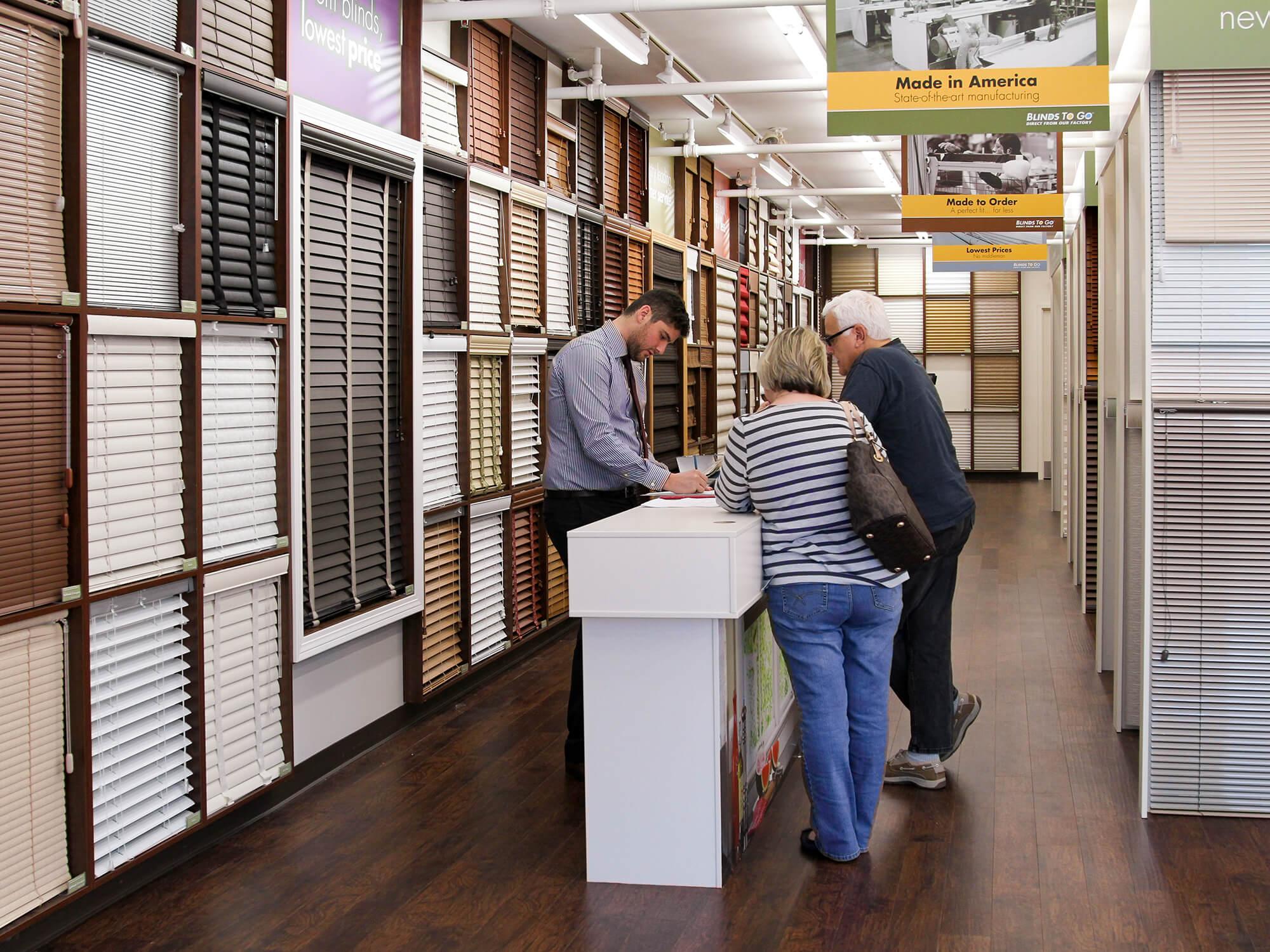A knowledgeable design consultant at a Blinds To Go showroom guides customers with a purchase.