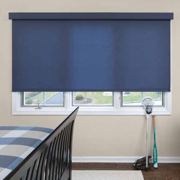 A modern bedroom has a large window covered with a modern looking large blue roller shade.