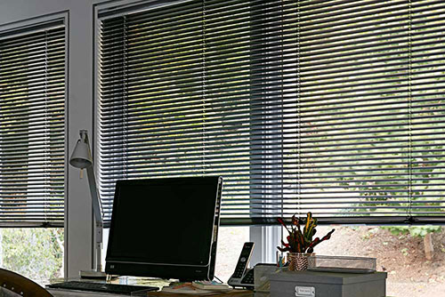 Black Aluminum blinds add sophistication and functionality to this home office workspace.