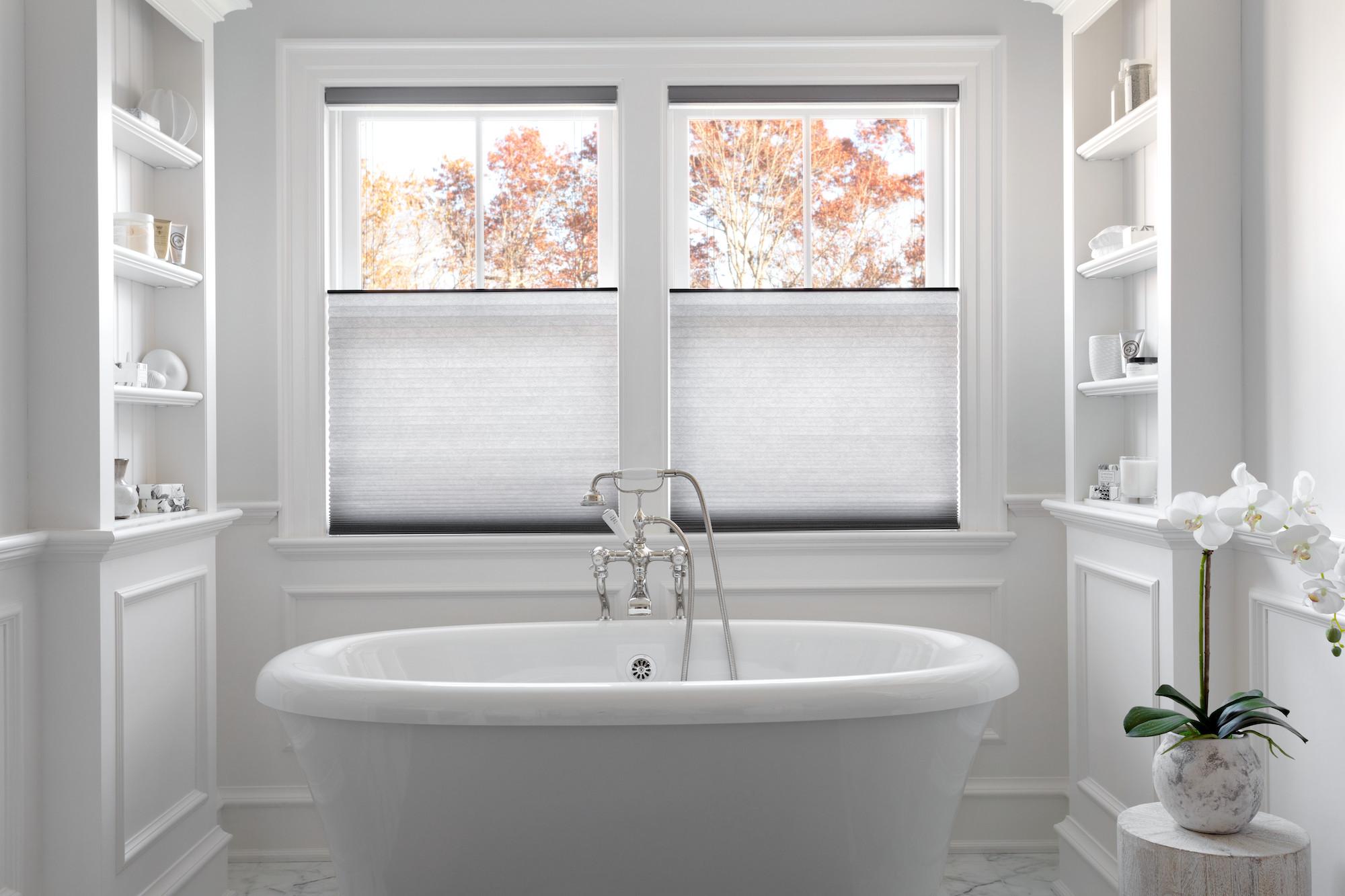 Modern bathroom bathed in light with top-down bottom-up cellular shades in white. 