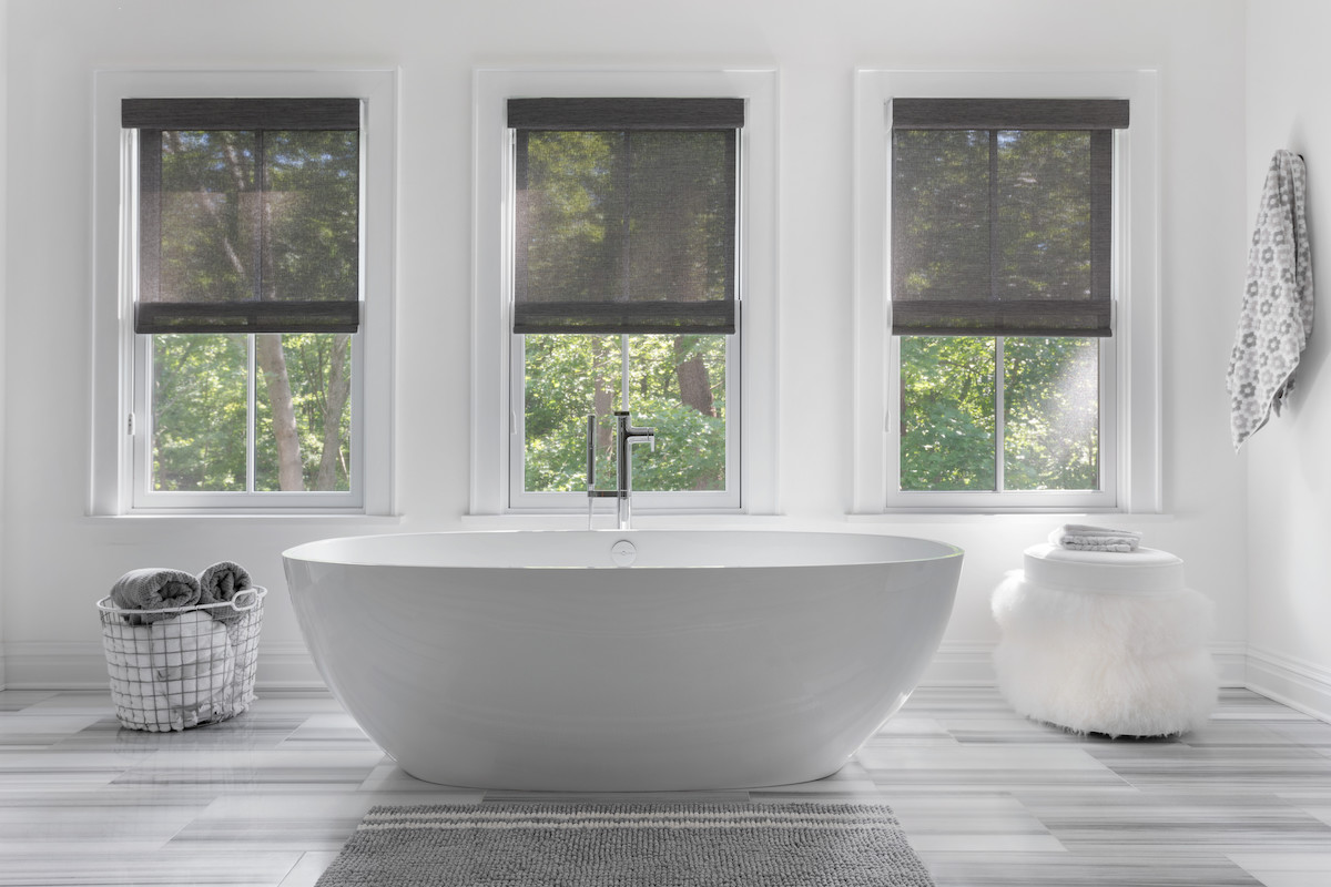 Reduce glare, and relax in comfort: Semi-transparent solar shades in this modern bathroom.