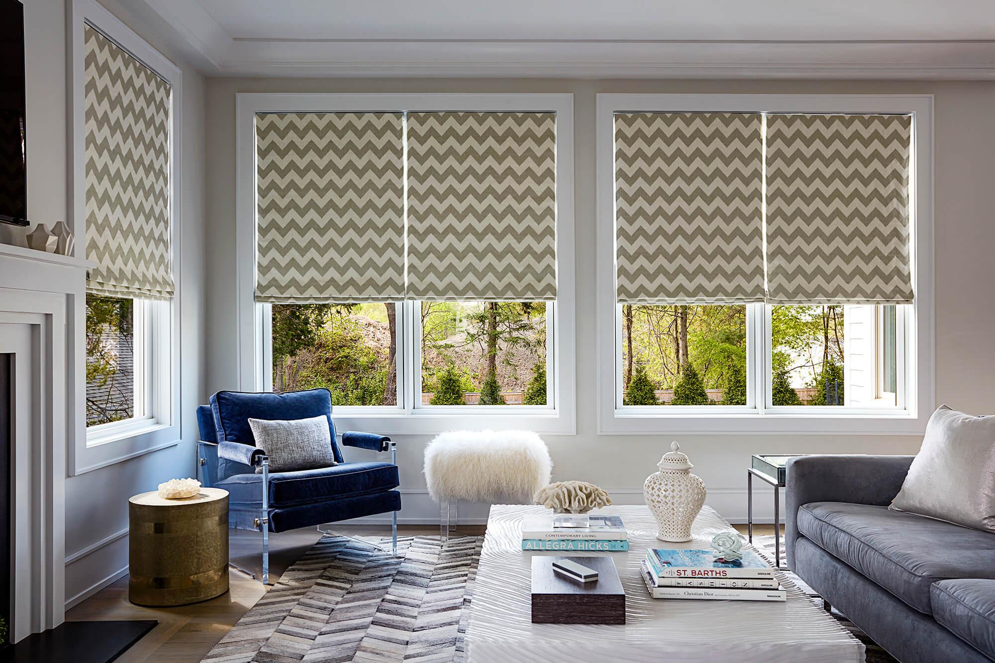 A living room flaunts warm, filtered light through elegant Roman shades.