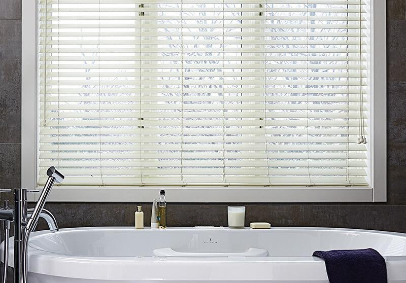 Sleek and modern motorized wood blinds add  privacy and light control to a modern bathroom.