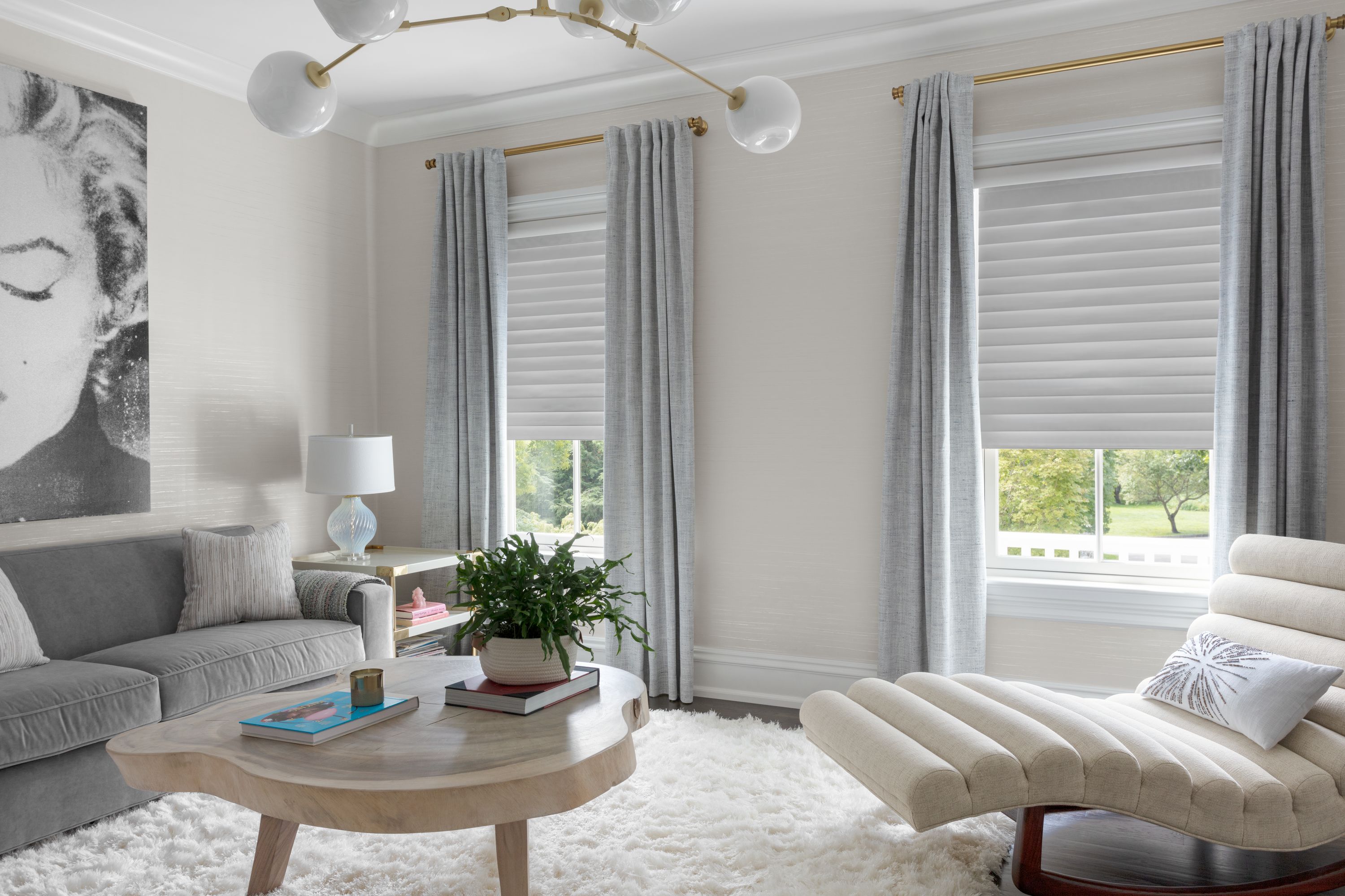 In a living area, White Dove Serenity sheer shades are complemented with gorgeous curtains on a brass rod.