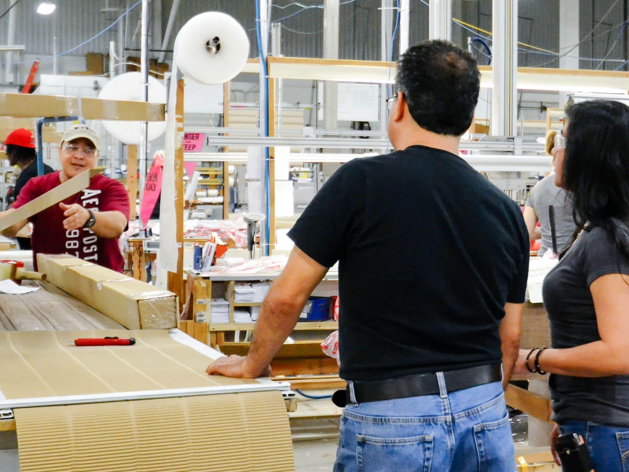 Employees at the Blinds To Go Factory packaging products.