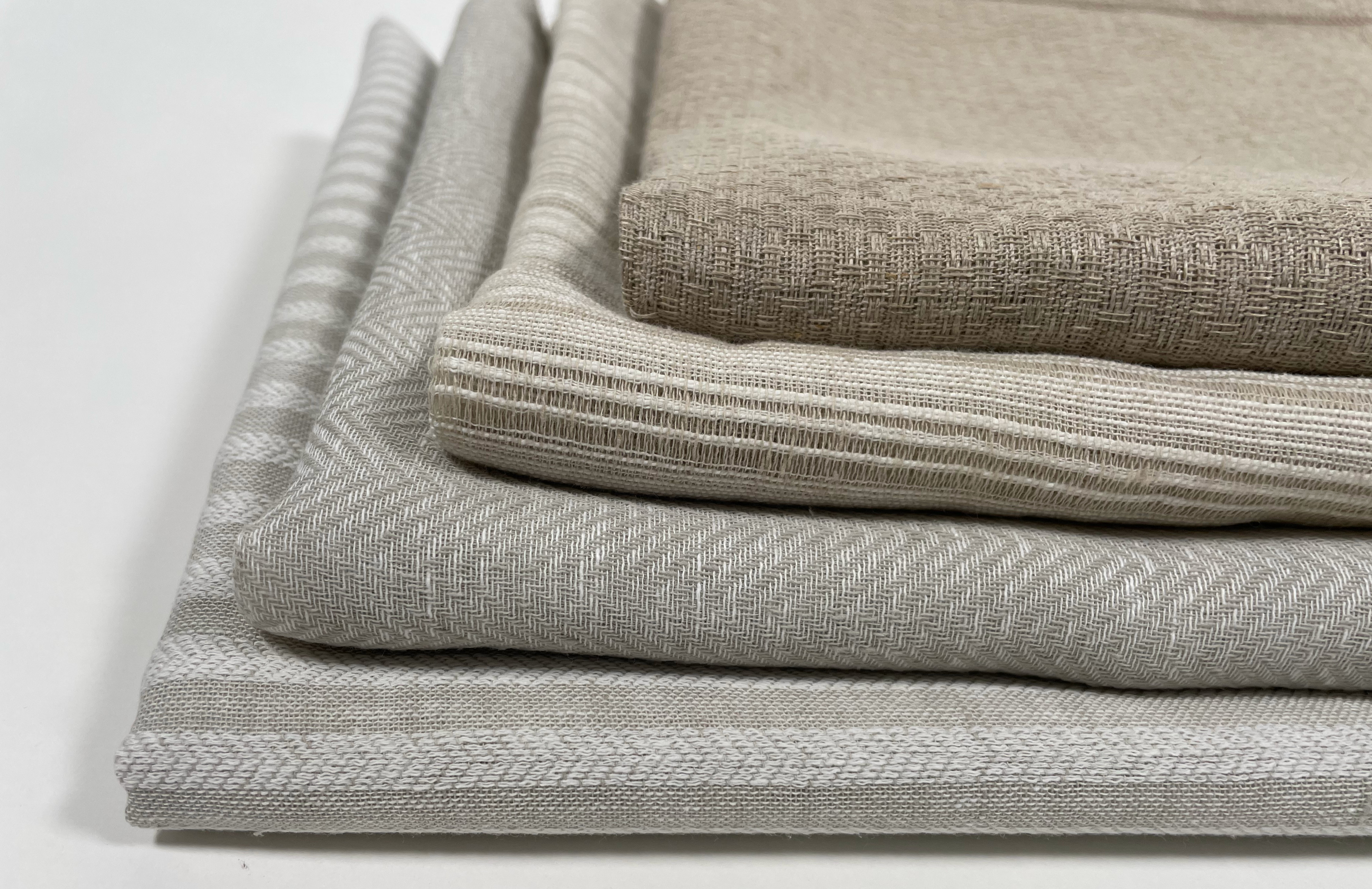 A few neutral fabrics are arranged in a stack.