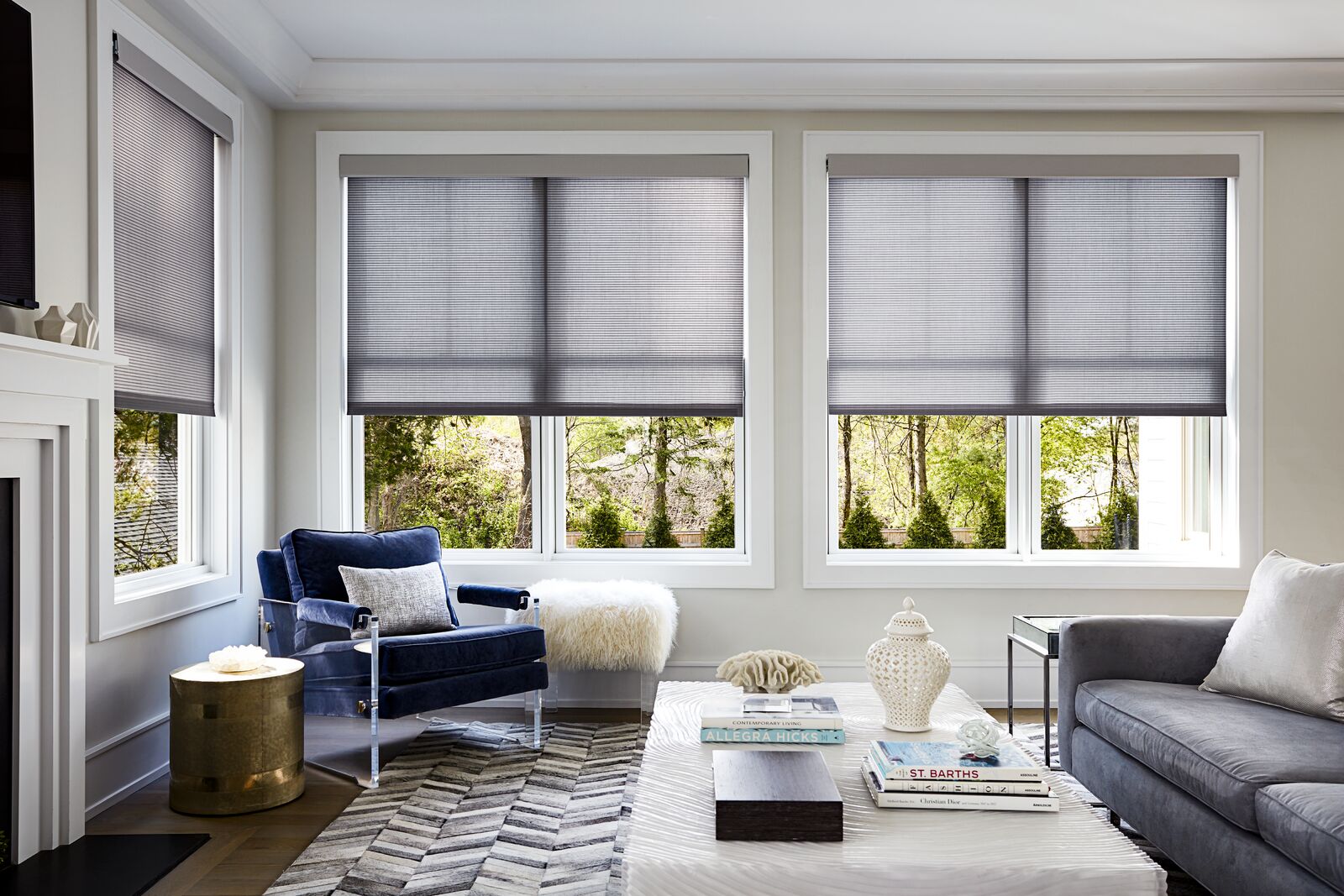 Roller shades cover two large windows in a modern living room