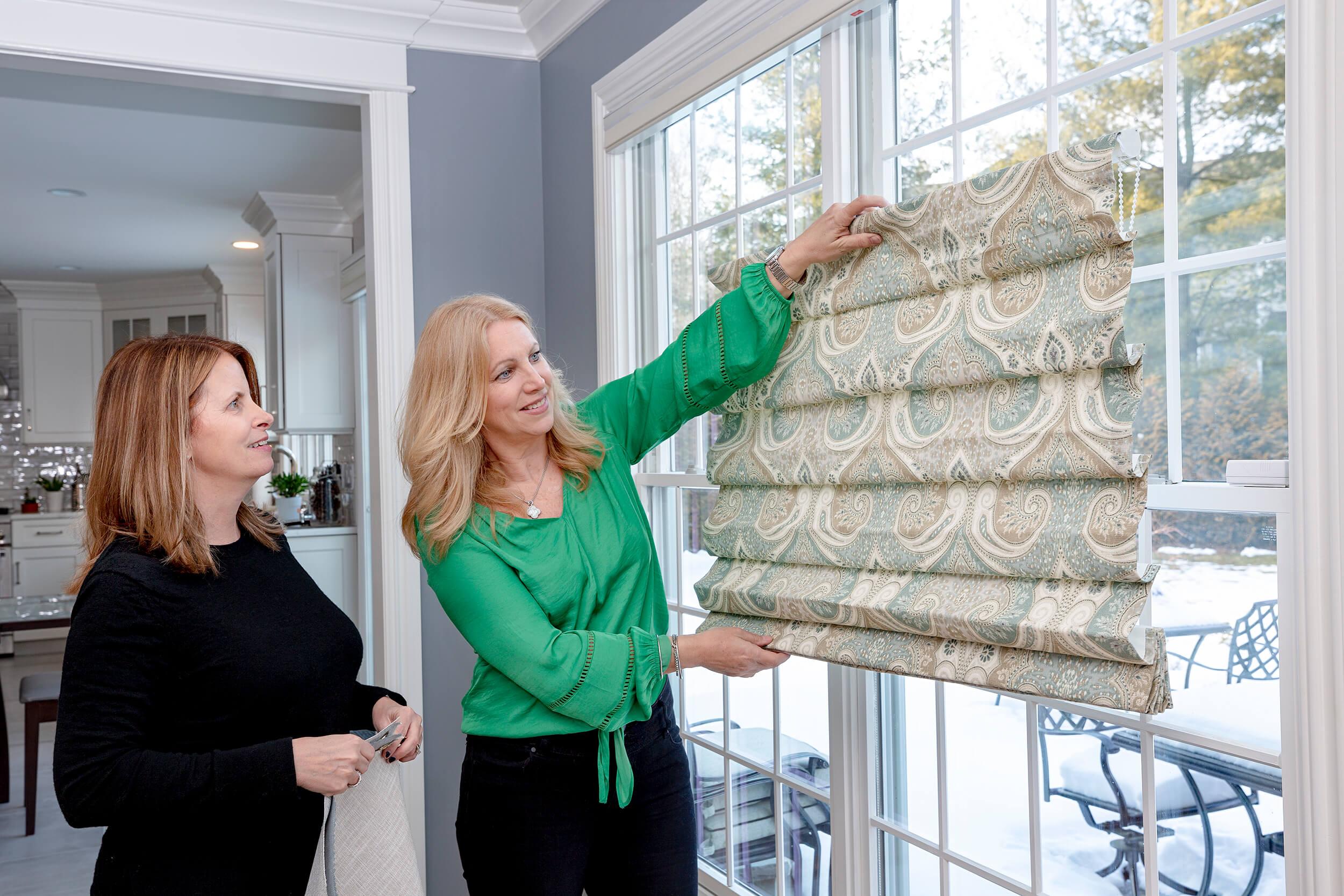 Shop at Home consultant showing a customer a roman shade