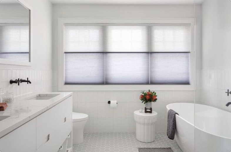 A large bright bathroom features day and night cellular shades.