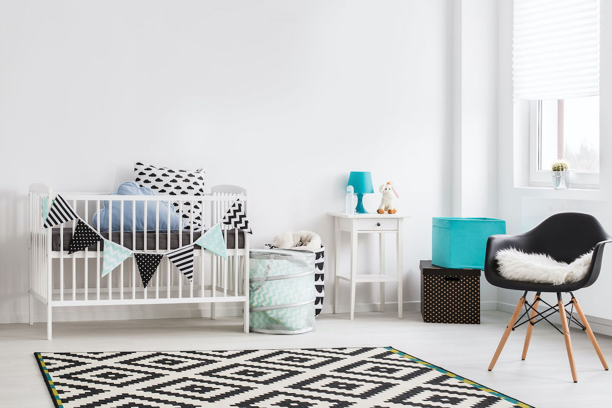 A cellular shade covers the window in bright, fun nursery.
