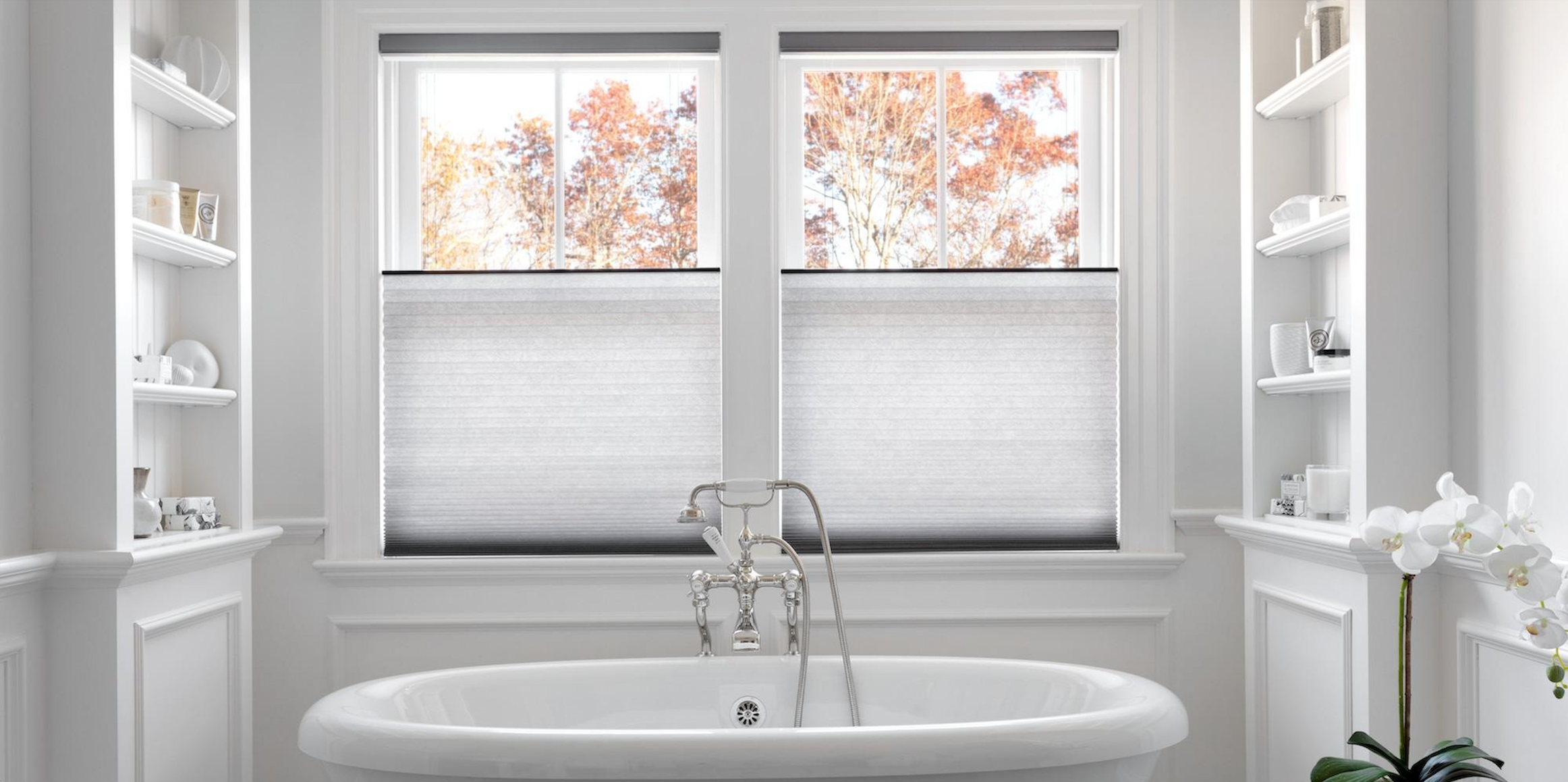 Two side-by-side windows showcase white cellular shades with the top lowered to let light in.