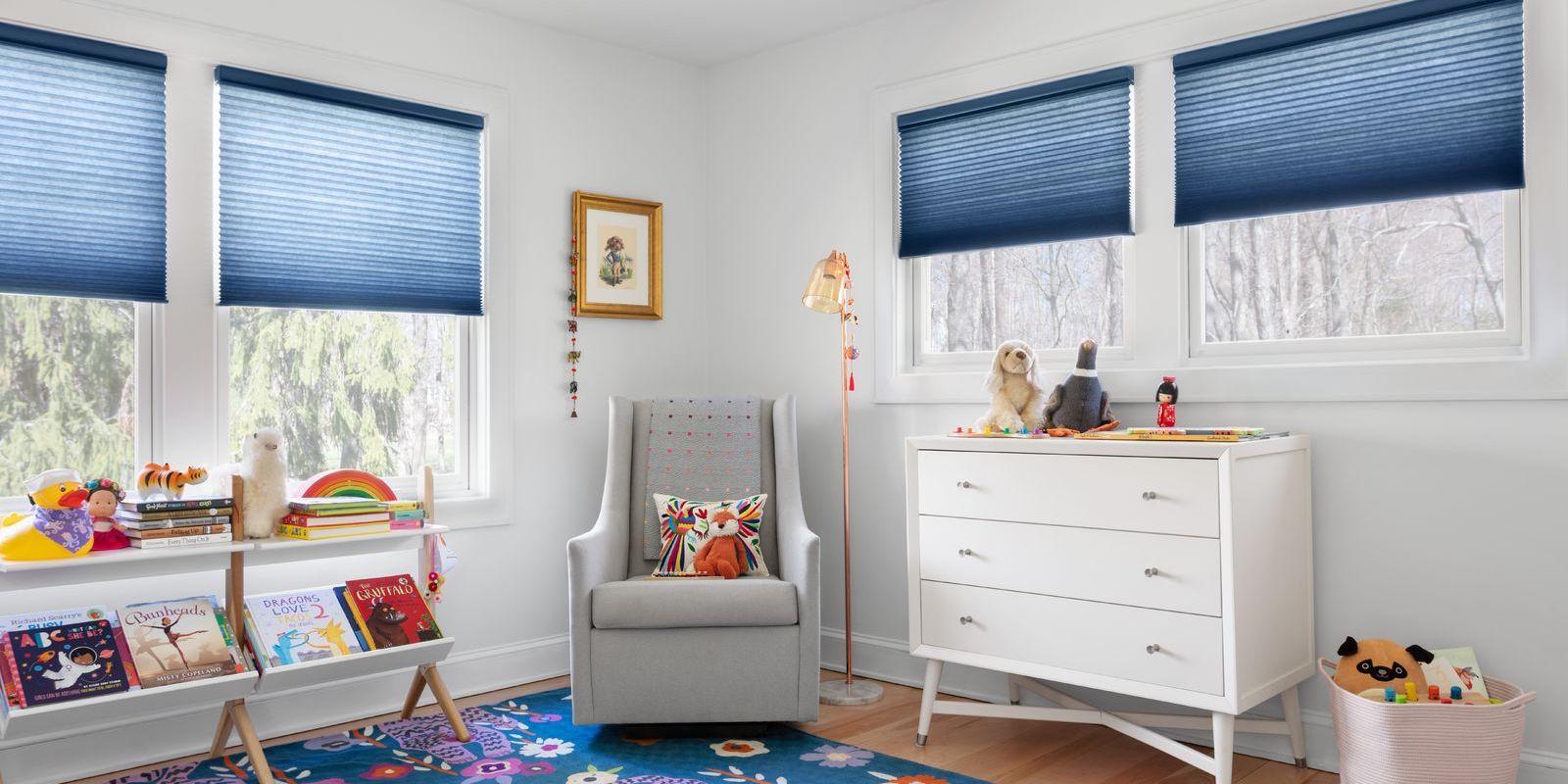 A playful kids room features blue cordless cellular shades on four windows.