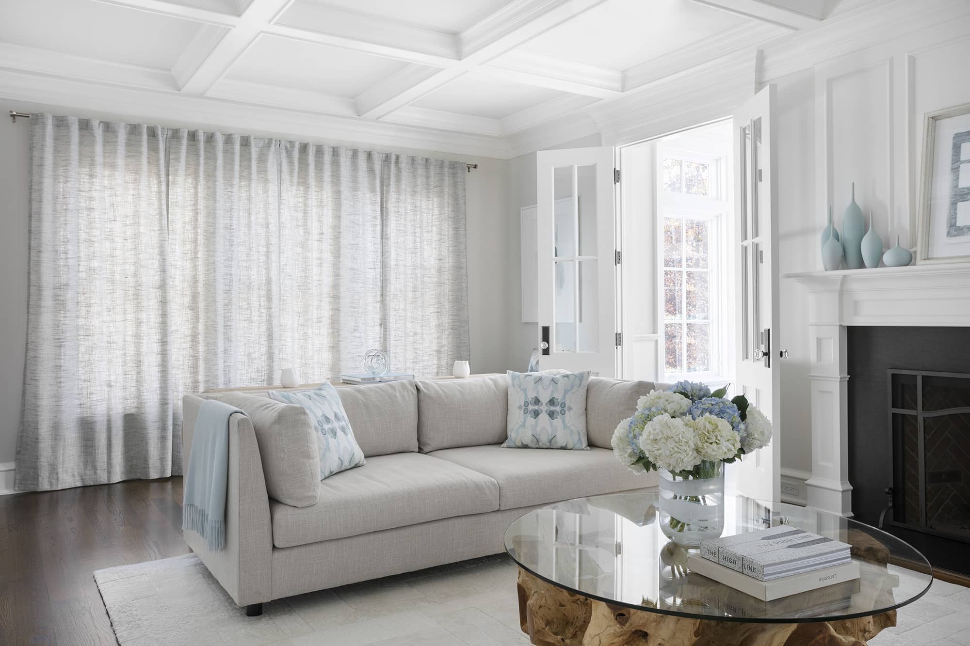 A living room with light grey textured sheer drapes