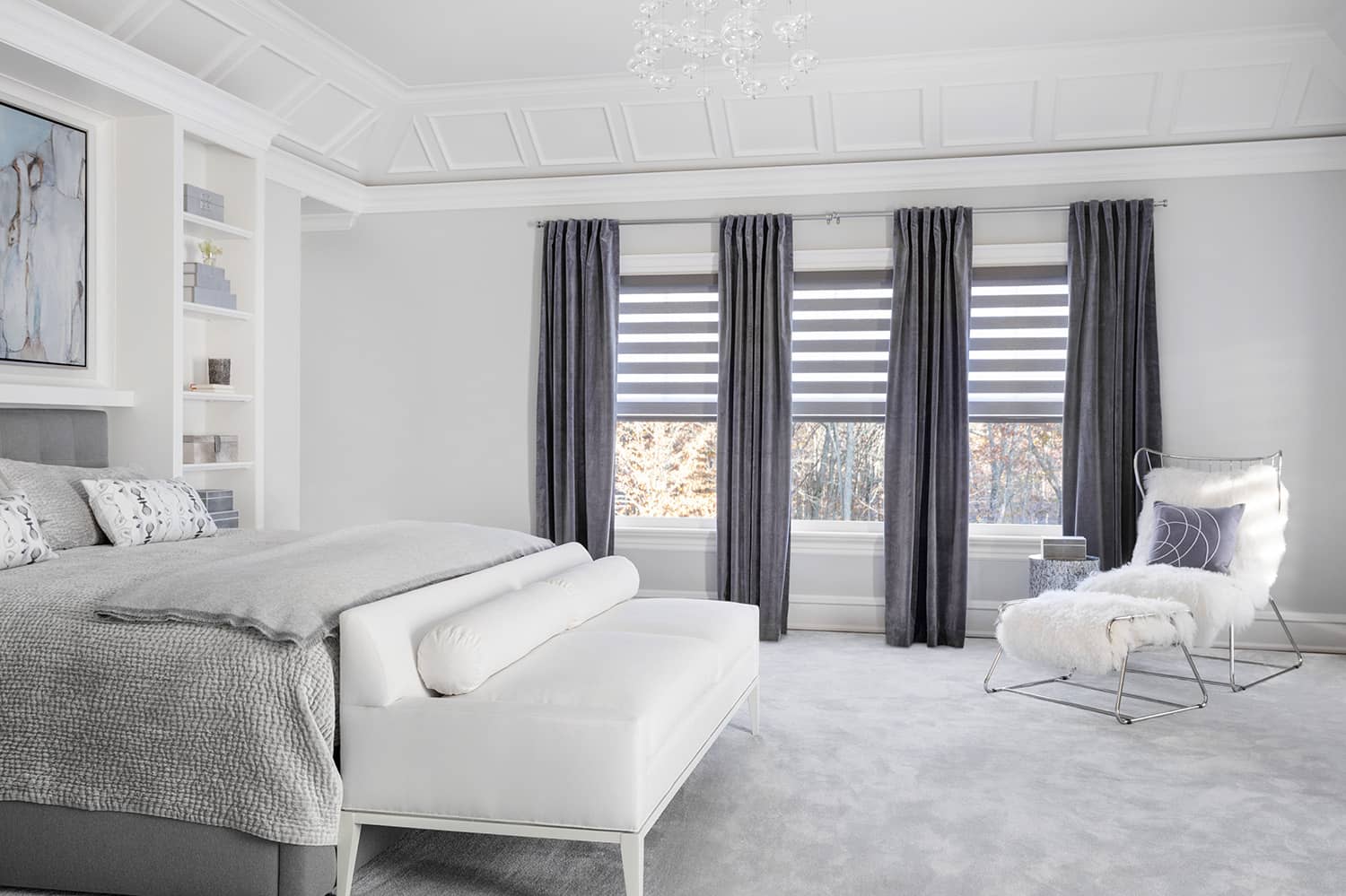 Blackout drapes paired with cascade sheer shades cover three windows in a contemporary bedroom