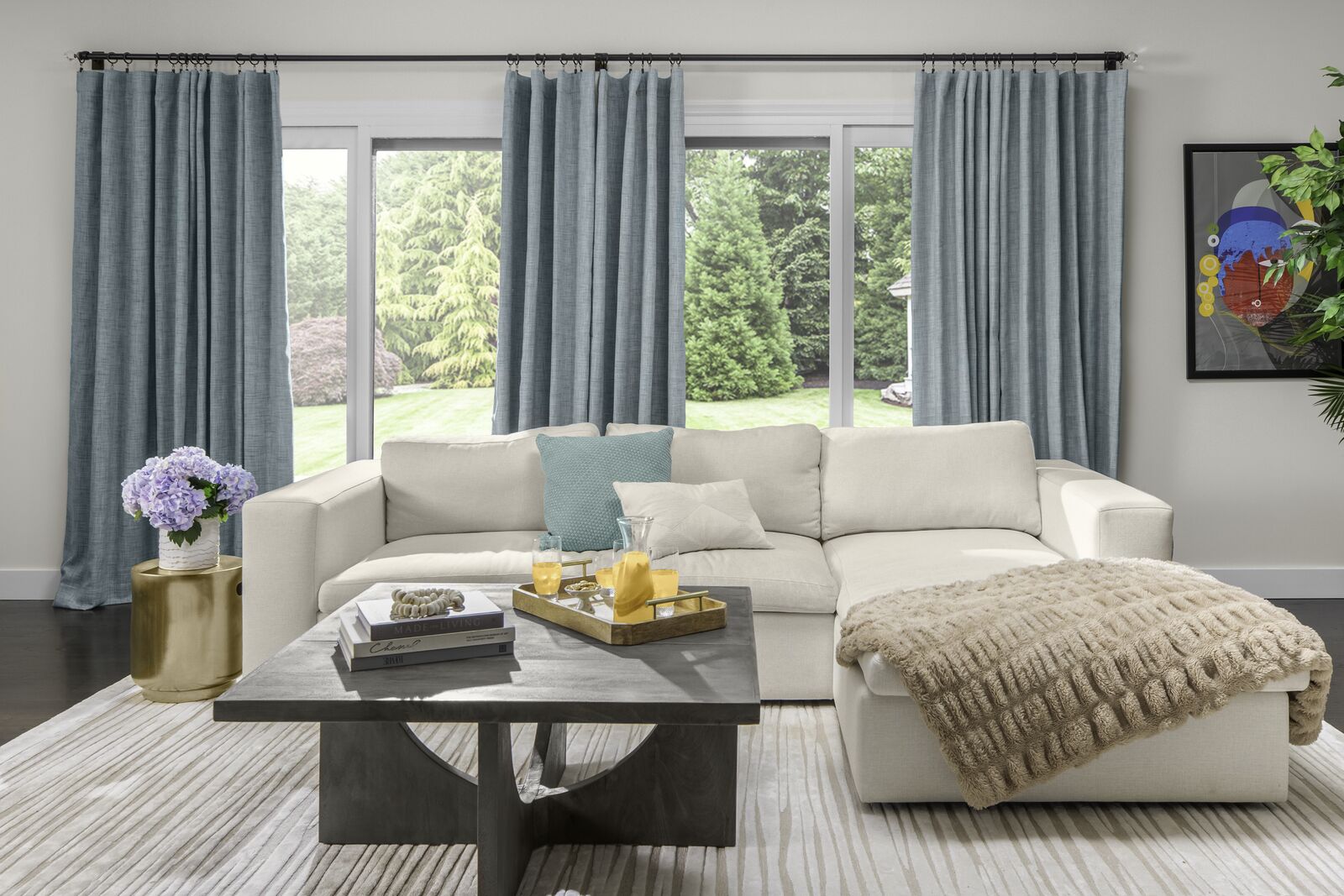 A modern living room features beautiful light teal drapery on a large window.