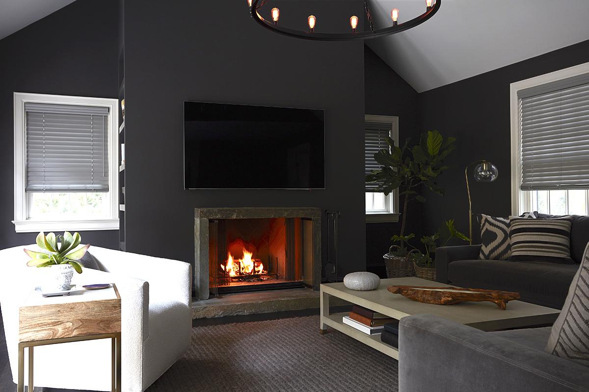 Grey faux wood blinds in a cozy family room with a fireplace and dark grey walls