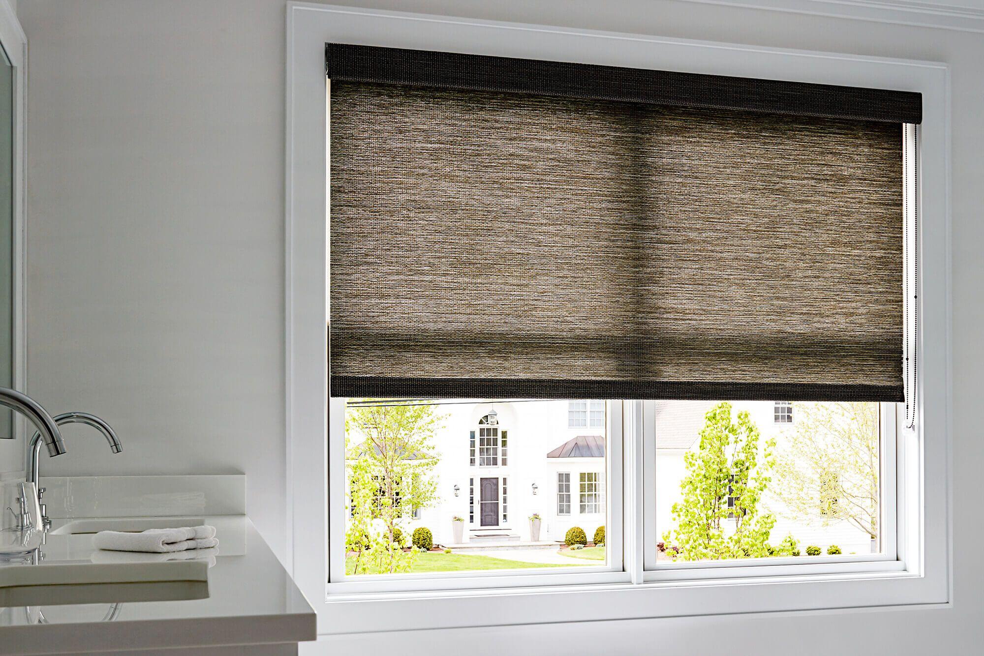 Naturally inspired woven wood material roller shade adds warmth to a mostly-white, spacious bathroom