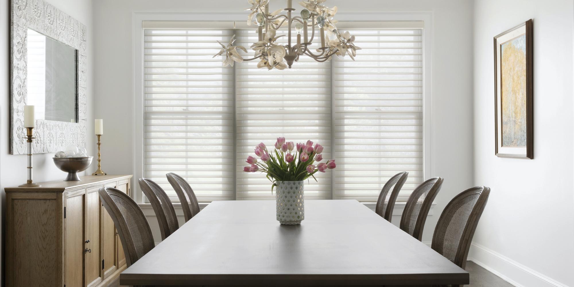 Light pours into a dining room with large windows partially covered with Serenity sheer shades in white
