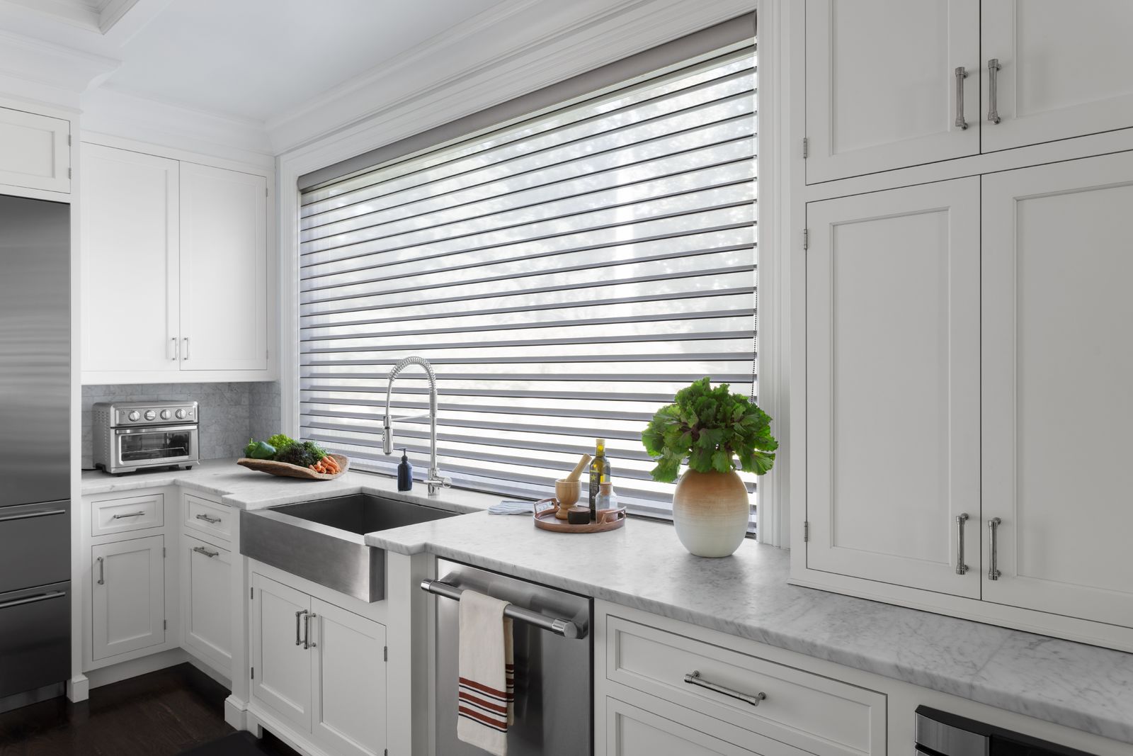 A large kitchen window features light grey Serenity sheer shades.