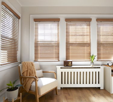 Real wood blinds tilted open in a bright sunroom. Real wood blinds tilted open in a bright sunroom.