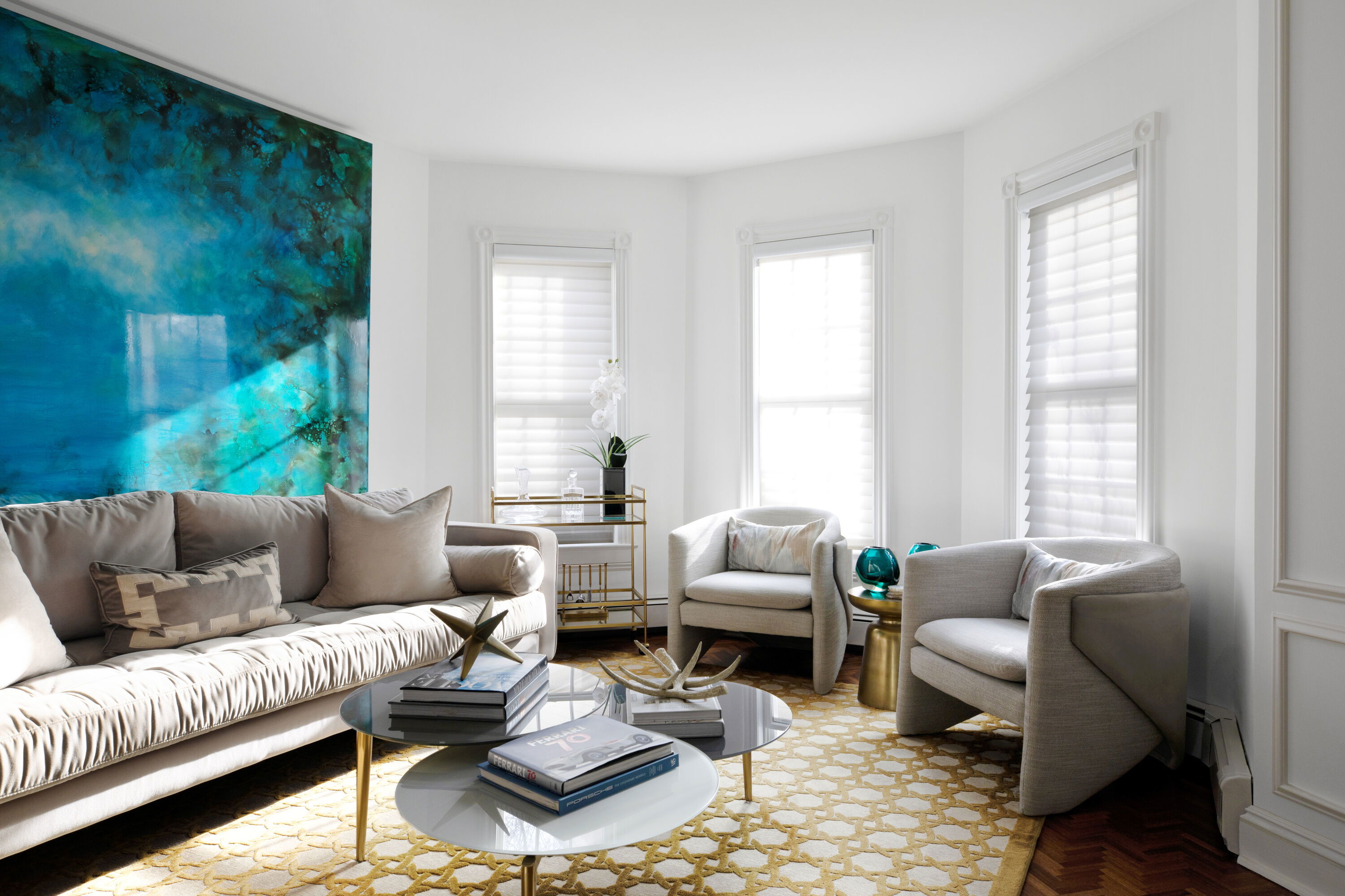 Bright modern living room with sheer serenity shades styled to infuse light, bold teal wall art, and a stylish graphic yellow rug.