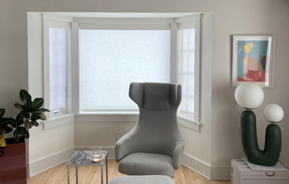 A bay window features white light-filtering roller shades A bay window features white light-filtering roller shades