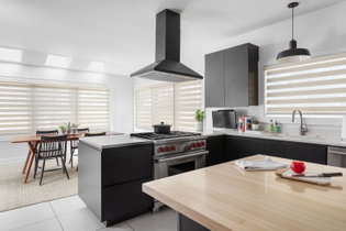 Tan Cascade sheer shades cover seven windows in a modern kitchen and adjoining dining room.