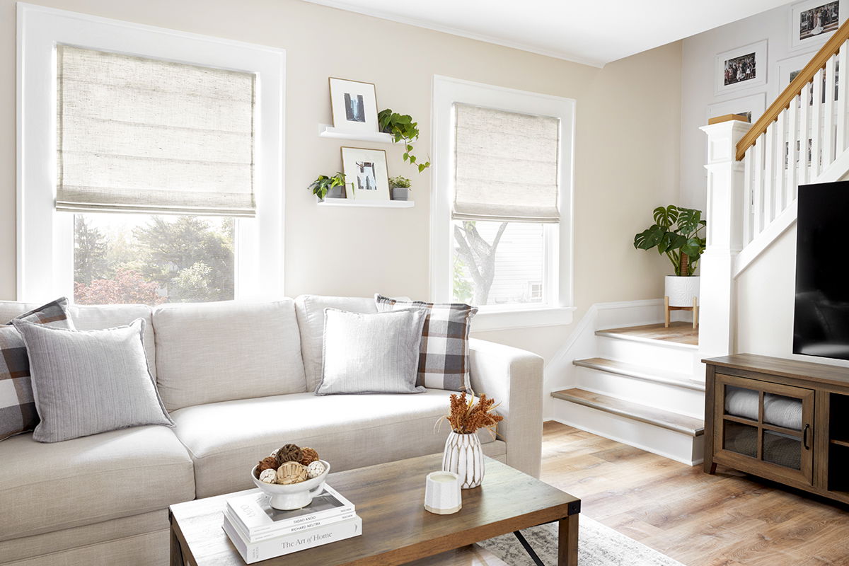 Natural off-white flat fold roman shades in a modern living room. Natural off-white flat fold roman shades in a modern living room.