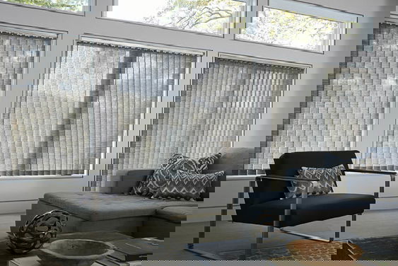 Vertical blinds made of custom fabric for sliding glass doors provide privacy and a modern room.