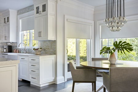 Dining area with white roller shades on windows Dining area with white roller shades on windows
