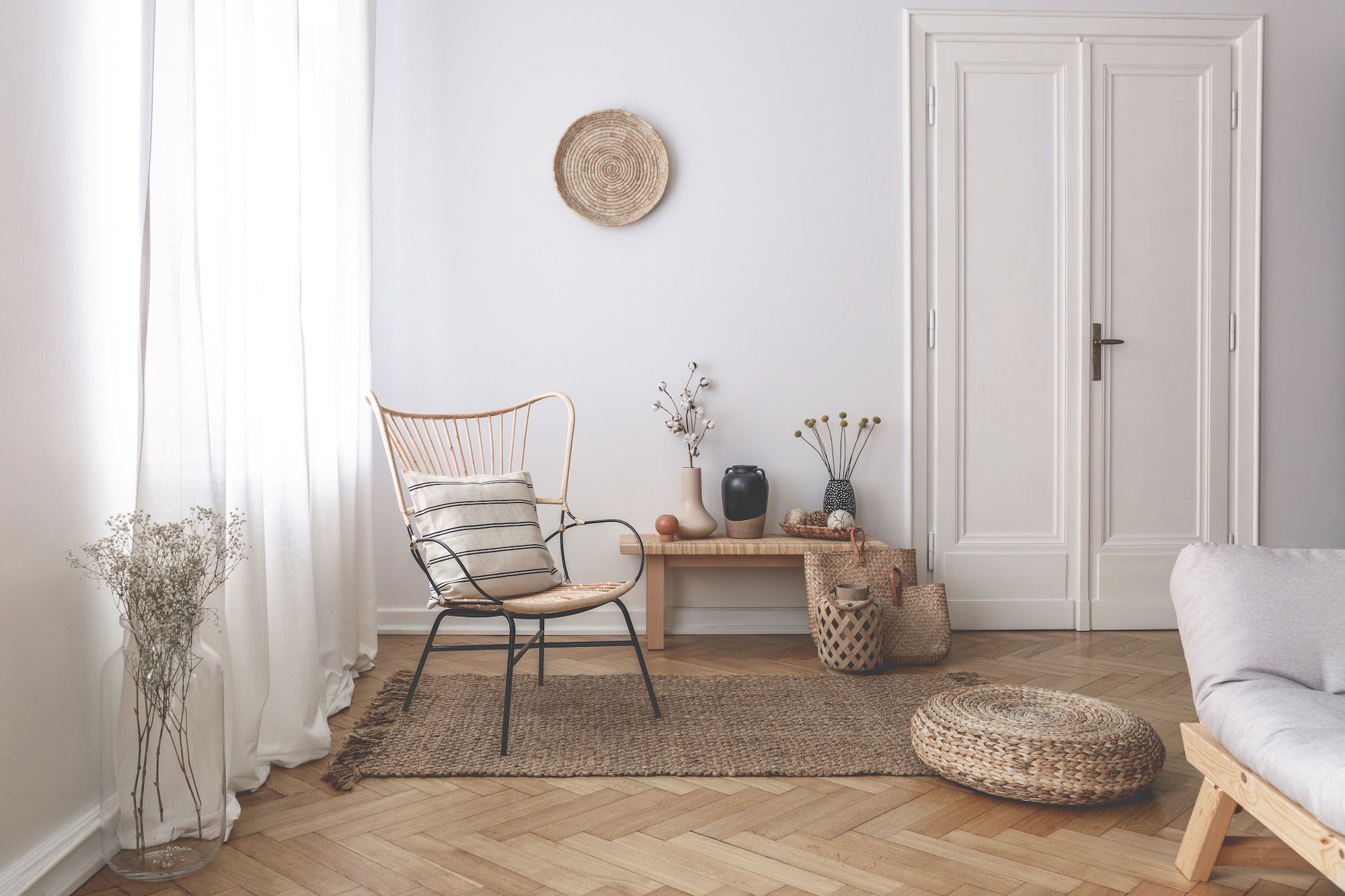 Light-filtering white drapery cover a wall of windows in a sparsely decorated modern sitting room Light-filtering white drapery cover a wall of windows in a sparsely decorated modern sitting room