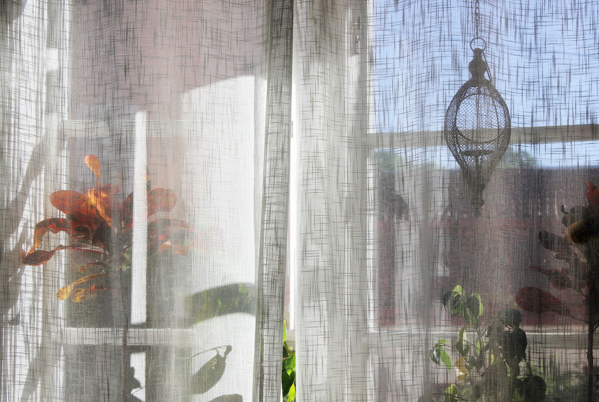 Light shines through sheer curtains Light shines through sheer curtains