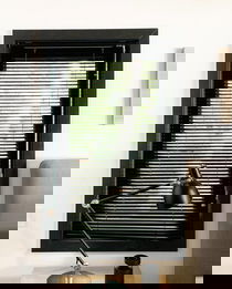 Aluminum blinds look custom in a black window frame