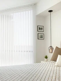 Vertical sheers offer daytime privacy without restricting the view on a large window in a modern bedroom Vertical sheers offer daytime privacy without restricting the view on a large window in a modern bedroom