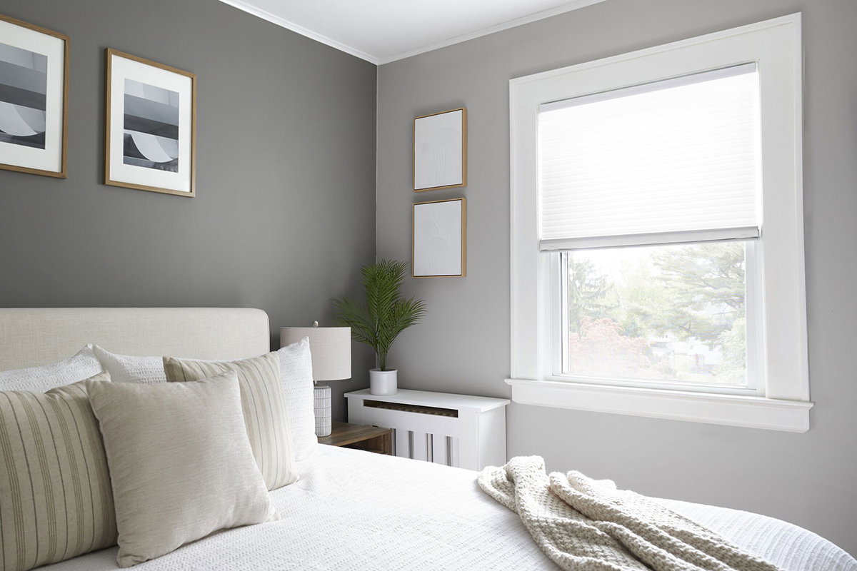 White light-filtering cellular shades provide privacy in a modern bedroom. White light-filtering cellular shades provide privacy in a modern bedroom.