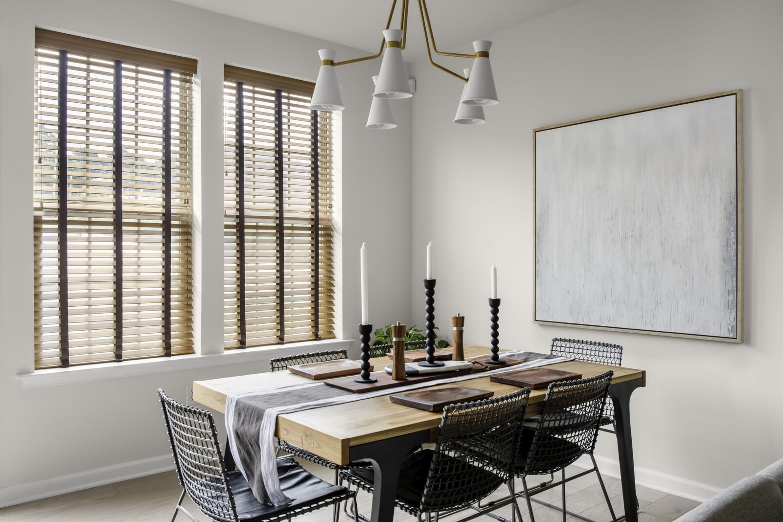Real wood blinds cover large windows in a modern dining room Real wood blinds cover large windows in a modern dining room