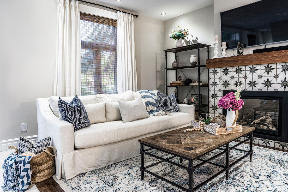 Sheer woven wood shades are paired with white curtains in a living room with modern bohemian decor Sheer woven wood shades are paired with white curtains in a living room with modern bohemian decor